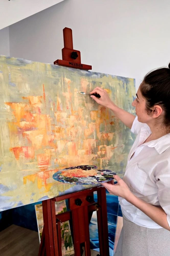 Mihaela Bozariu pictând în atelier